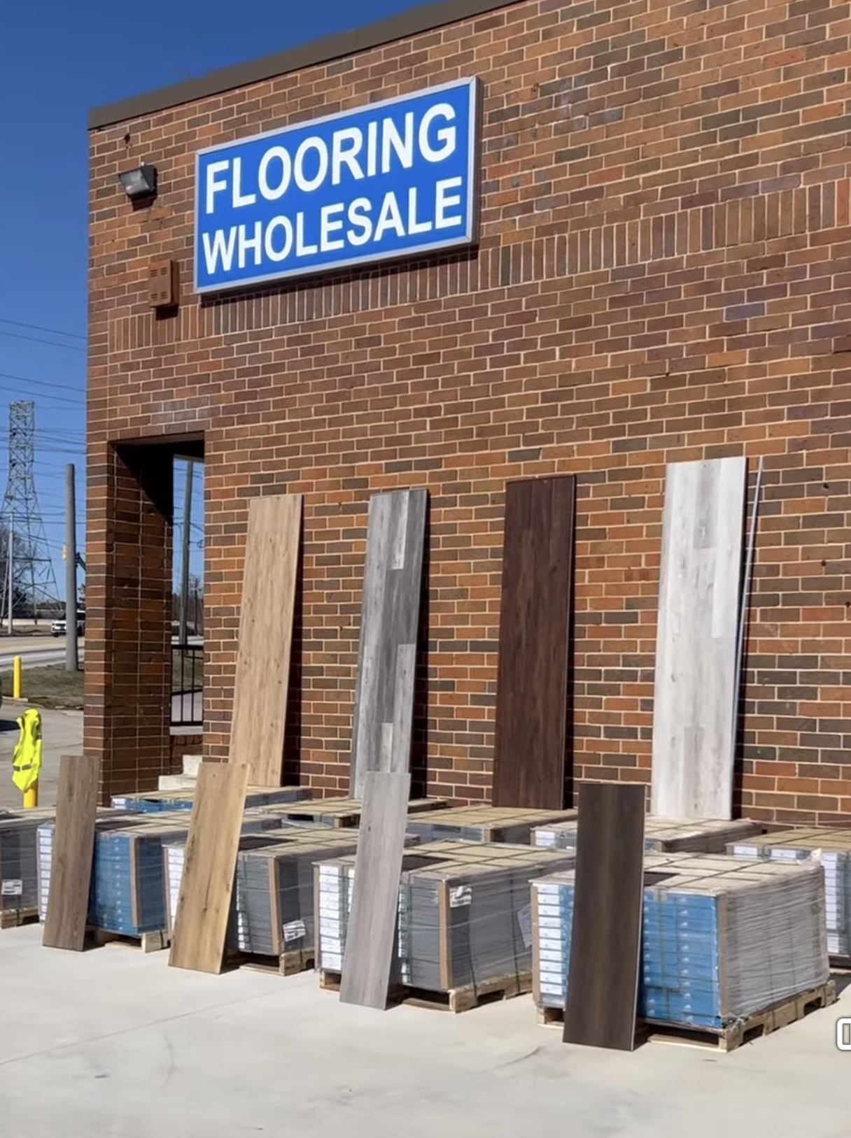 Budget Flooring & Supplies storefront with LVP and hardwood plank samples on display